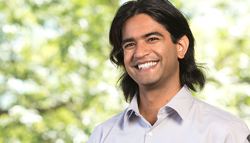 mayank is smiling with trees in the background