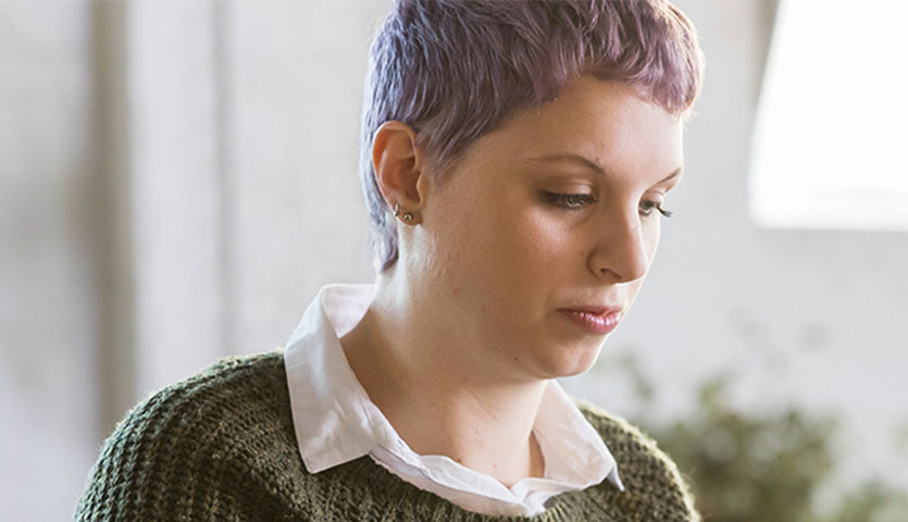 jess is wearing a green jumper in a bright room