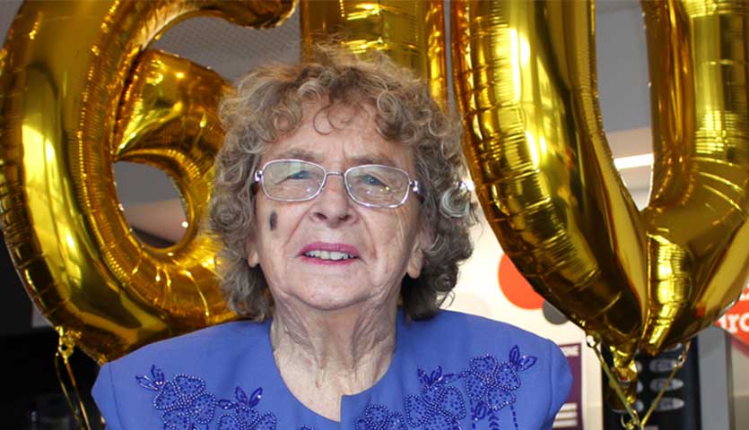 donor dawn jarrett in front of gold balloons with the number 600