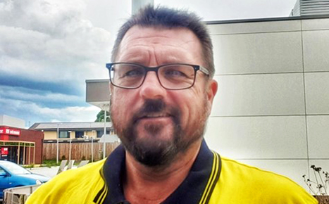 photo of donor Wayne smiling at the camera, he is wearing black framed glasses and a hi vis shirt