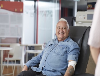 Donor Stephen is lying in a chair, with a bandage on his arm from donating plasma for the anti-D program