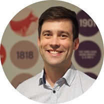 Patrick smiling in front of a feature wall of blood statistics