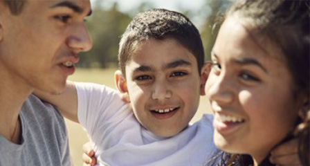 A young boy smiling with his family