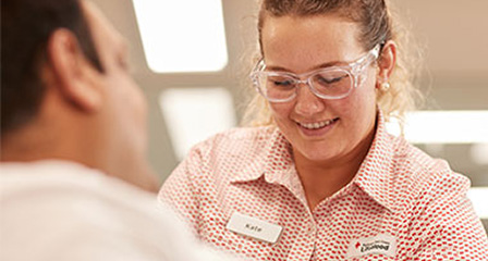 a nurse smilling at a person seated making a donation