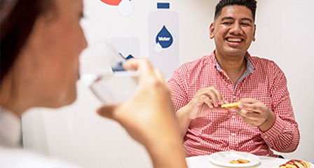 two people seated at a table in a donor centre having snacks