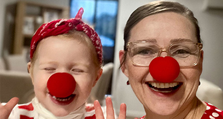 a baby and woman wearing red noses and laughing