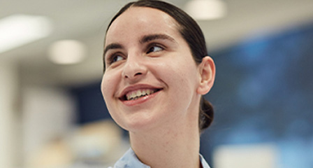 close up of a scientist looking over her right shoulder and smiling