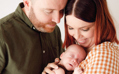 A mother and father holding a newborn baby