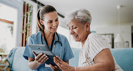 image of a nurse with a stethoscope having a conversation with a patient in front of an ipad