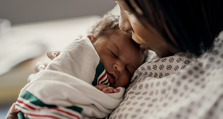 image of a mother holding a new born baby in a blanket
