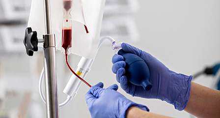 image of a blood in tube with a nurses hand