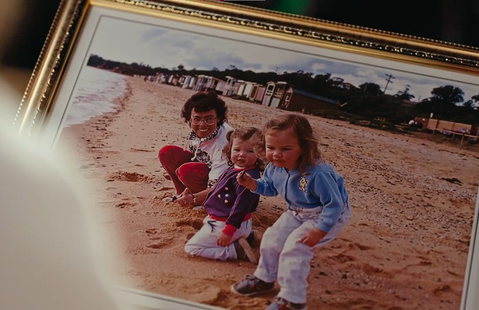 a photo of a mother and children on a beach