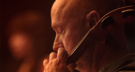 a man playing a cello on stage