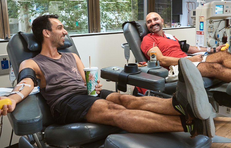 two men seated in a donor centre during a donation