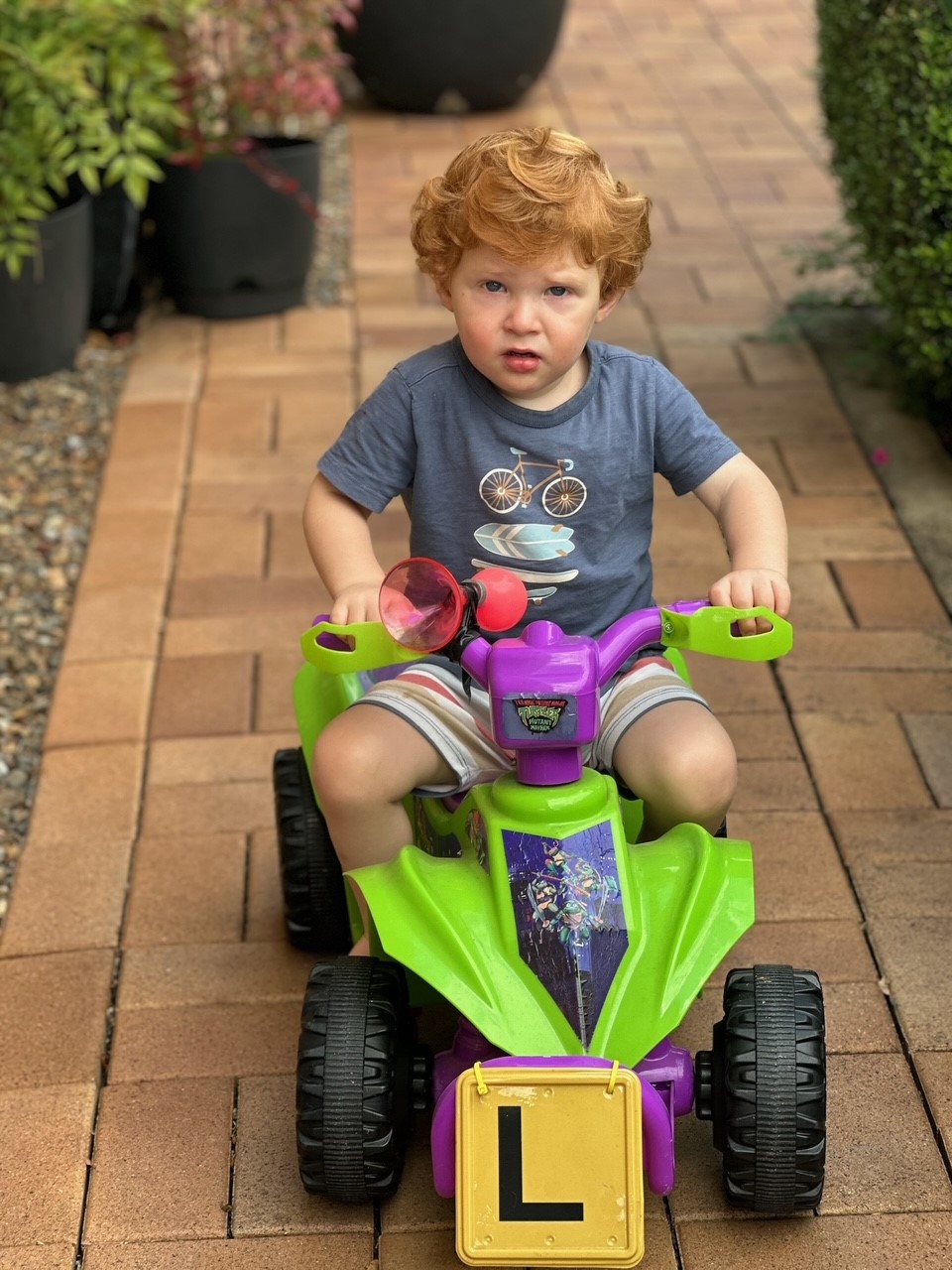 young boy on bike looking at camera