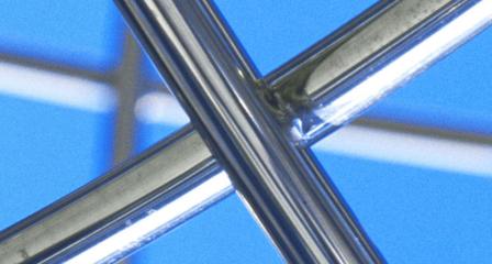 metal piping crossed over each other, blue sky is in the background