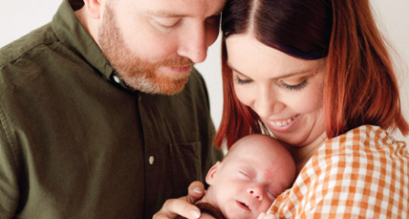 A mother and father holding a newborn baby
