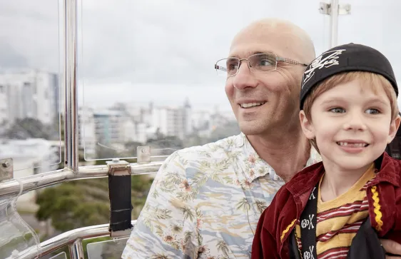 a man and his son are smiling with a view of the city in the background
