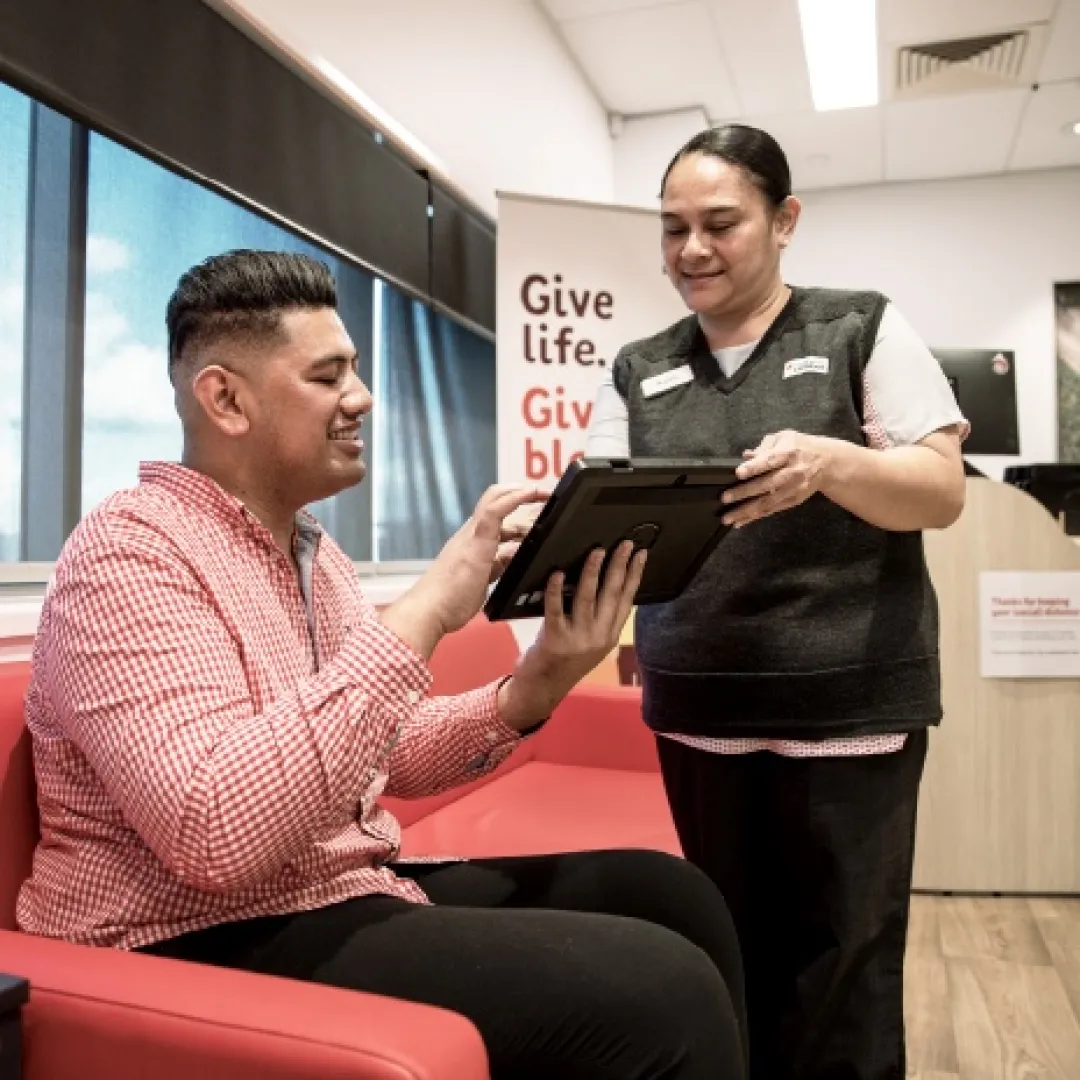 a person using an iPad while a staff member assists
