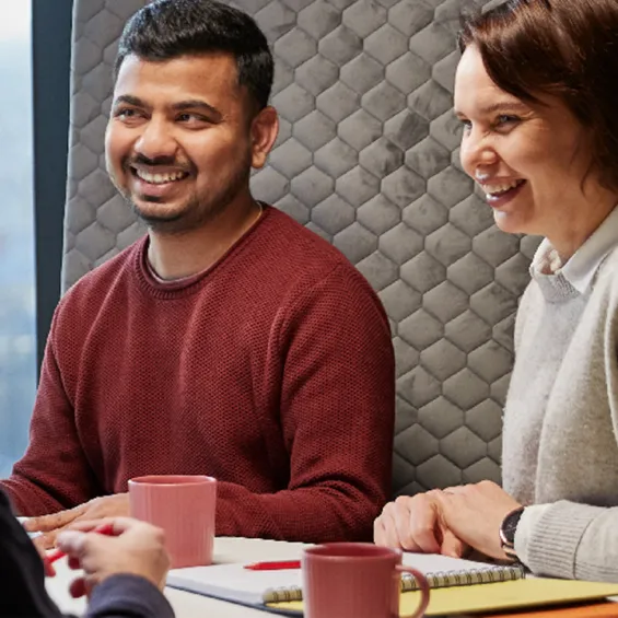 two people seated in an office smiling