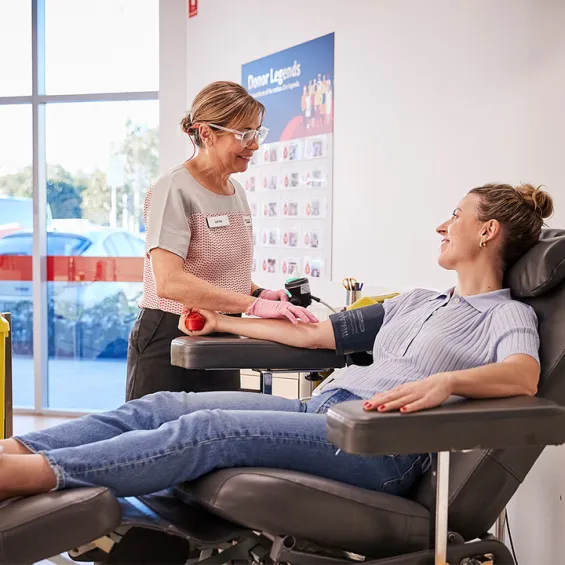 a nurse attending to a donor seated in a chair