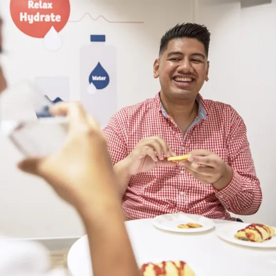 two people seated at a table in a donor centre having snacks
