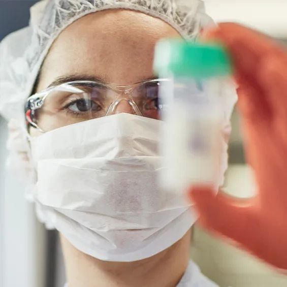 a scientist holding up a vial