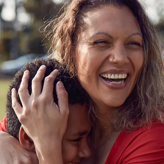 a woman smiling and hugging her son