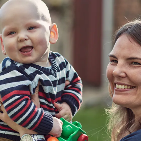 a mother and baby seated outside and smiling