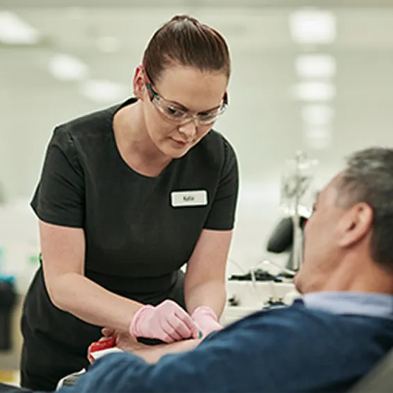 a nurse attending to a donor seated in a chair