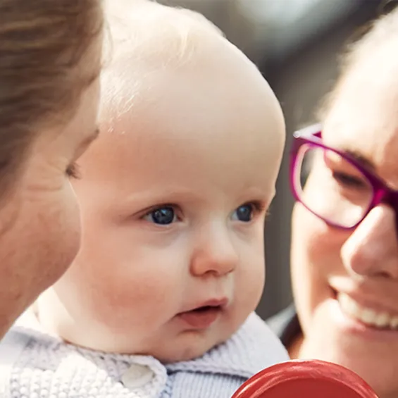 two women smiling with a baby