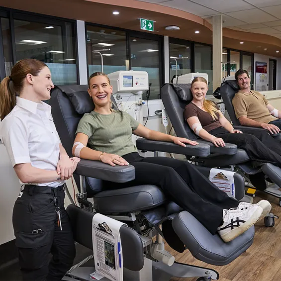 a group of friends during a donation smiling at one another