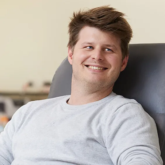a man seated and smiling