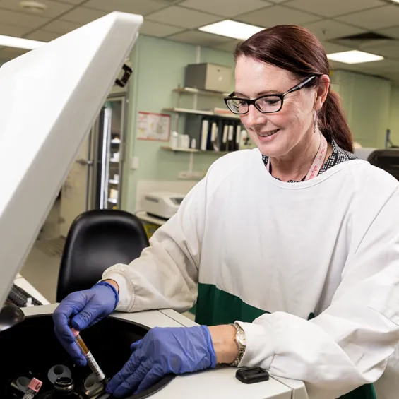 Image of a scientist holding a test tube inside a centrifuge