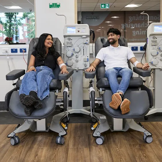 two people sitting next to one another and donating