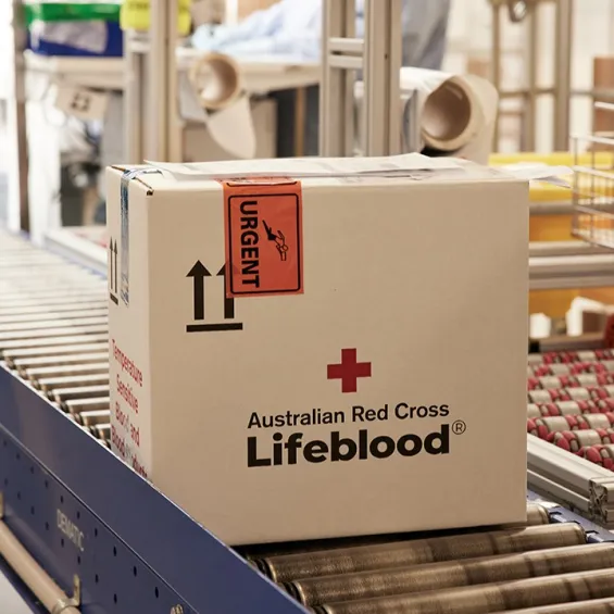 a box with the lifeblood logo on a conveyer belt