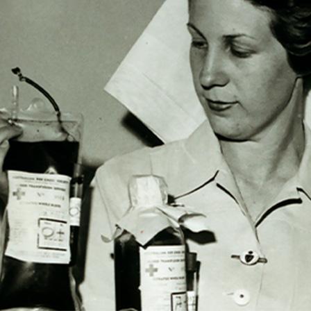 black and white image of female nurse holding blood bag