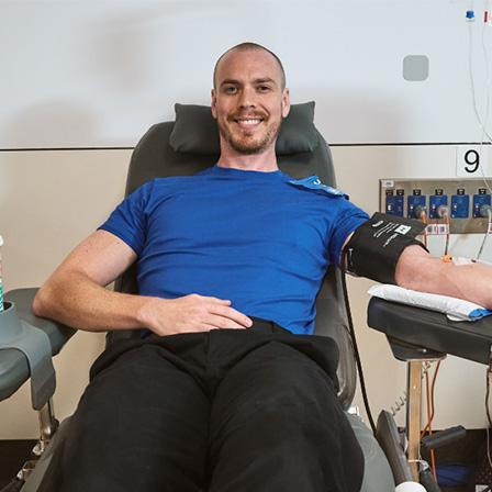 a man seated in a donor chair and smiling