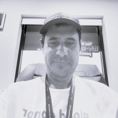 A man taking a selfie wearing a blood donor for life t-shirt, a lanyard and a cap