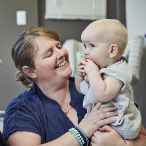Mother holding baby and smiling