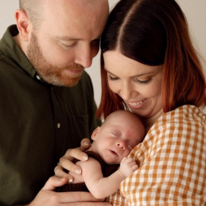photo of parents smiling with their baby