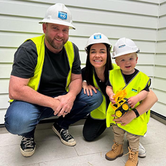 a family of three all wearing high vis and hardhats