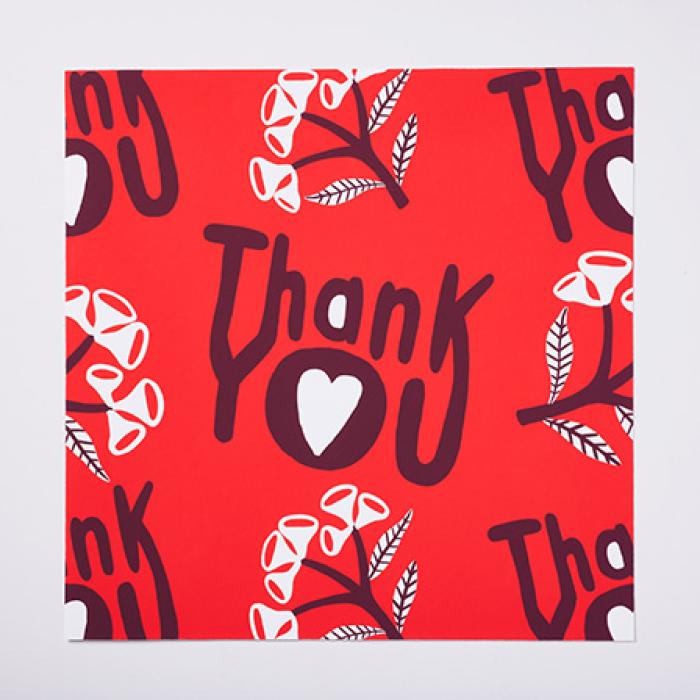 photo of the Madeleine Stamer design which is the words thank you with a love heart in the letter o, with a branches motif on a red background